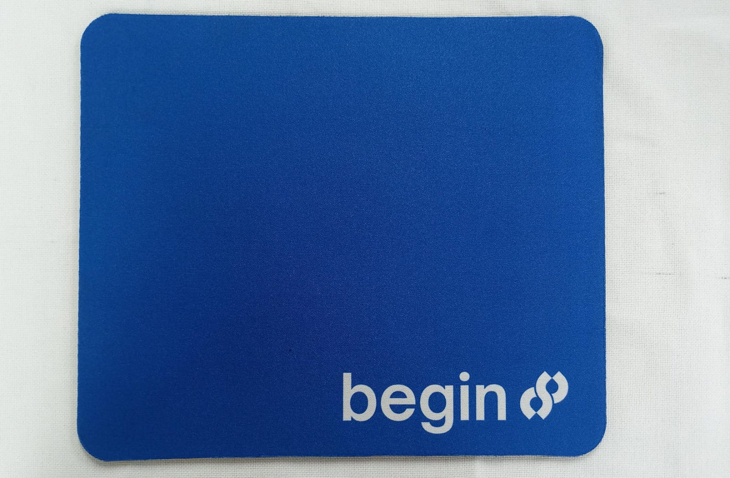 Blue personalized mousepad for office use featuring the word begin in white