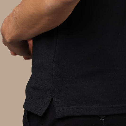 Close-up of side slit on black jacquard polo t-shirt, designed for better movement and comfort.