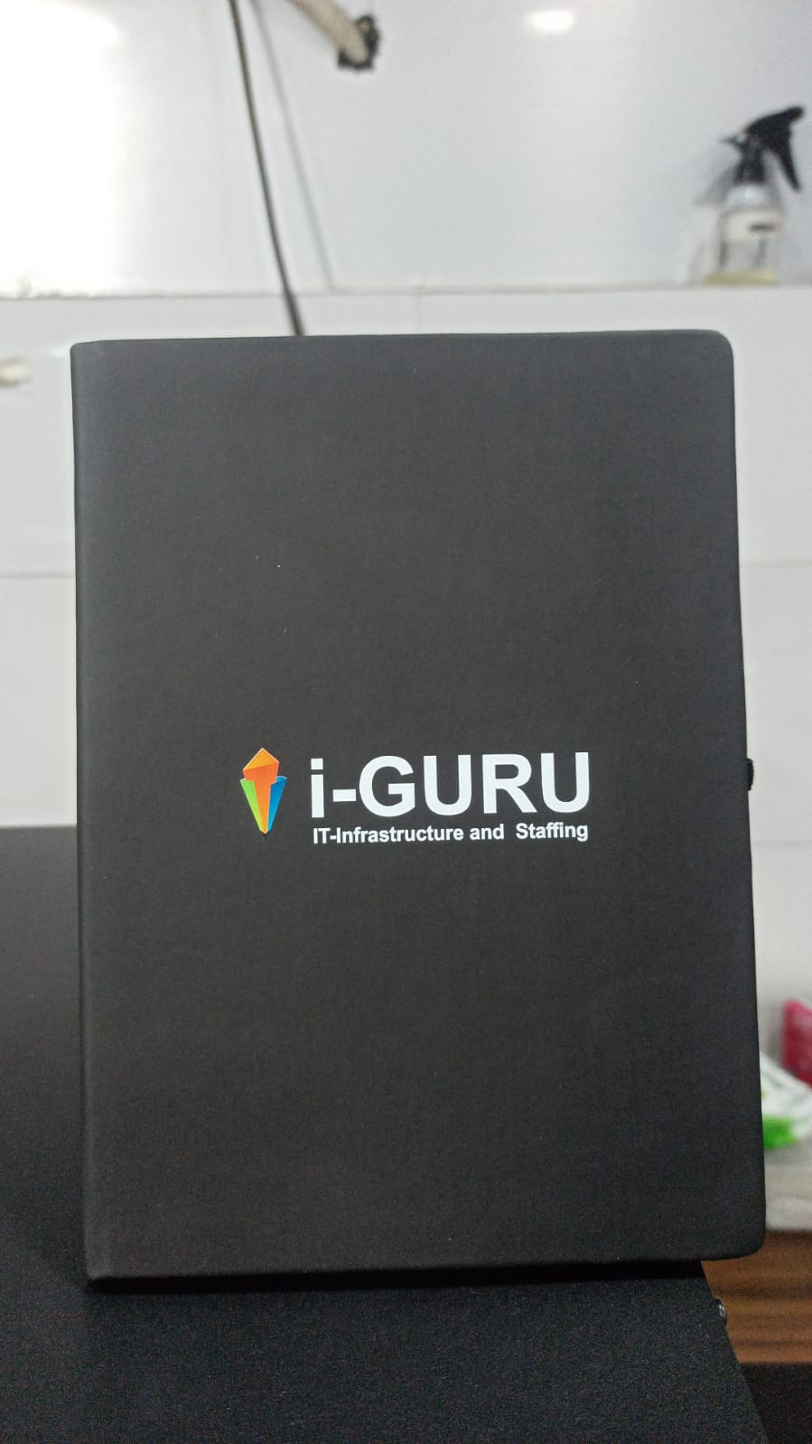 Personalized black notebook featuring i-GURU logo, ideal as customized A5 corporate gifts