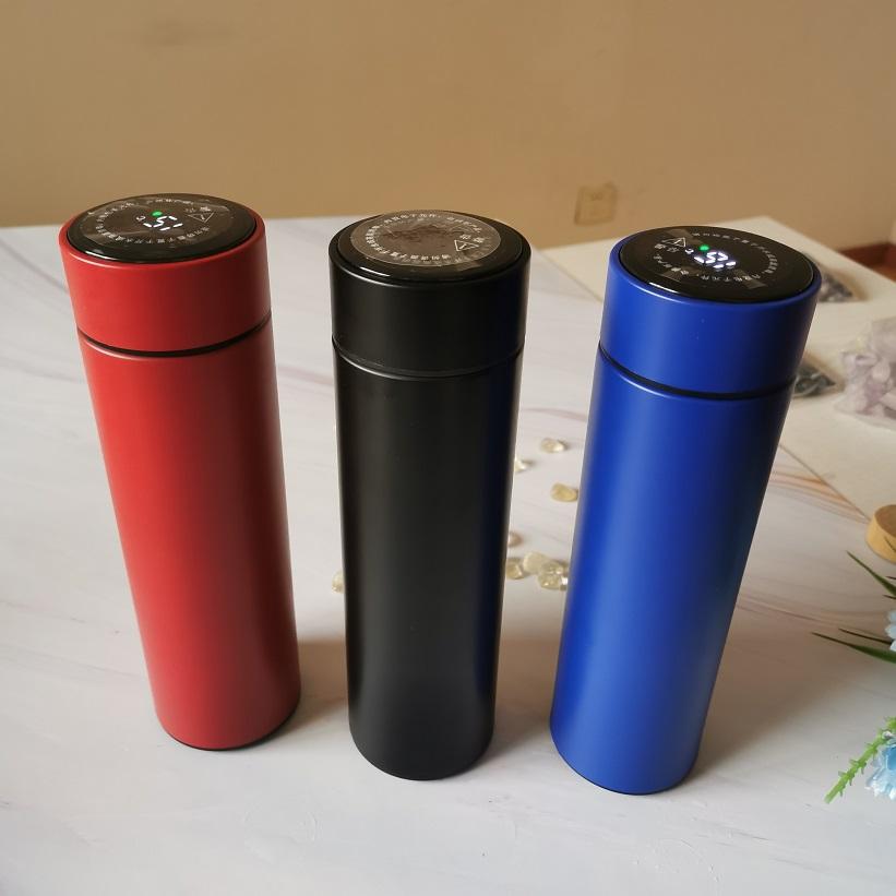 Personalized blue color temperature UV printed water bottle next to black and red bottles