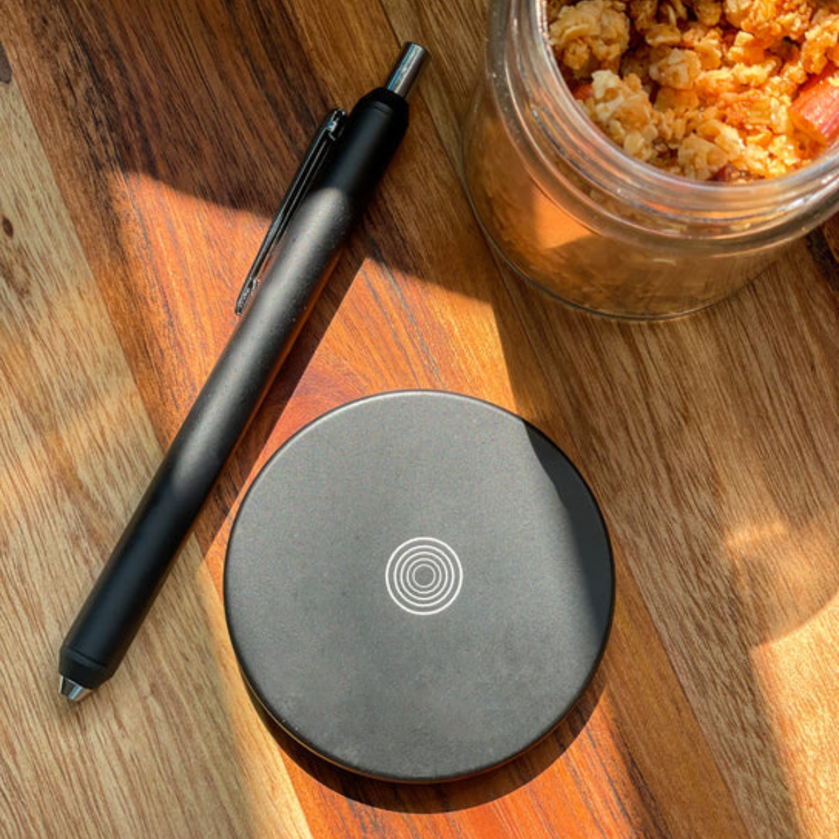 Personalized magnetic pen stand with a sleek black office pen on a wooden surface