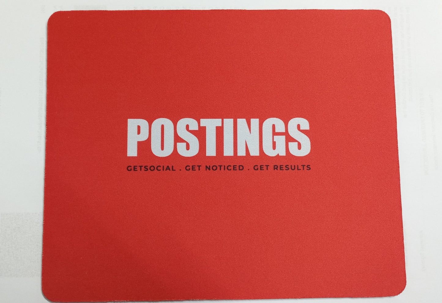 Red personalized mousepad for office use featuring the word POSTINGS in bold white letters