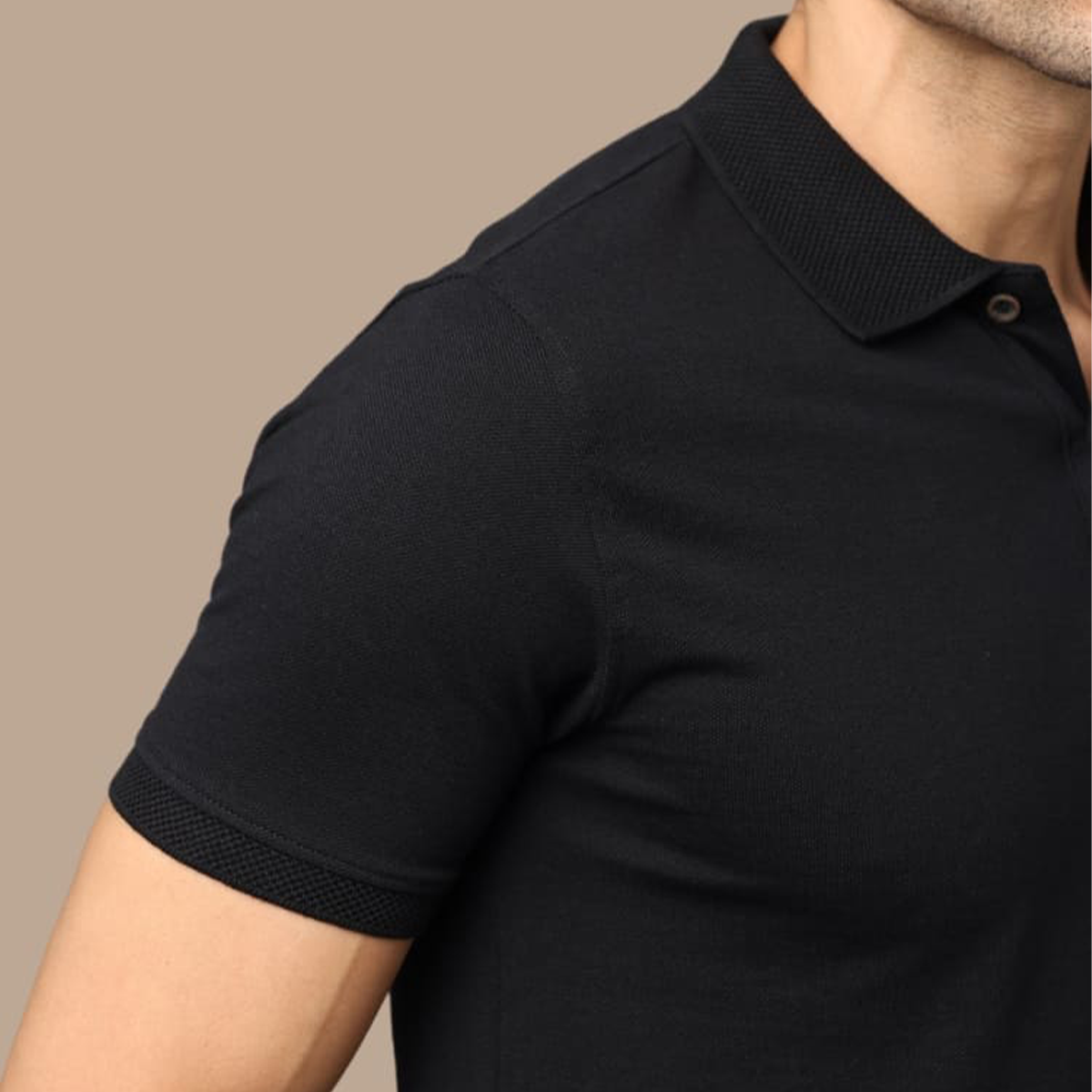 Close-up view of the jacquard collar and cuffs on the black polo t-shirt, highlighting the textured fabric and fine craftsmanship for a premium look.